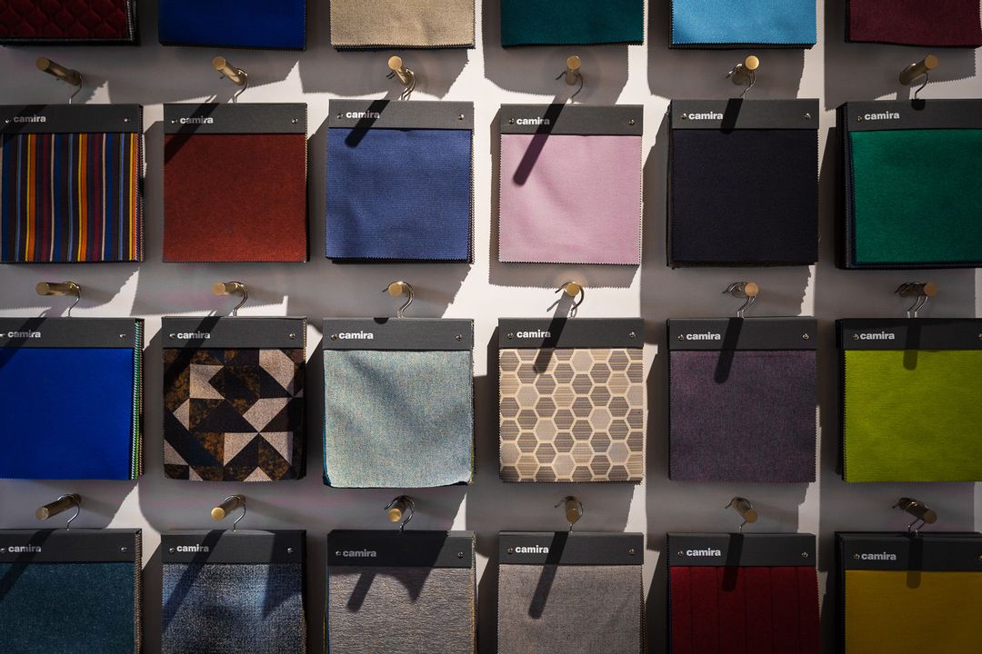 Close up of Camira's fabric swatches hanging from a bespoke made wall unit
