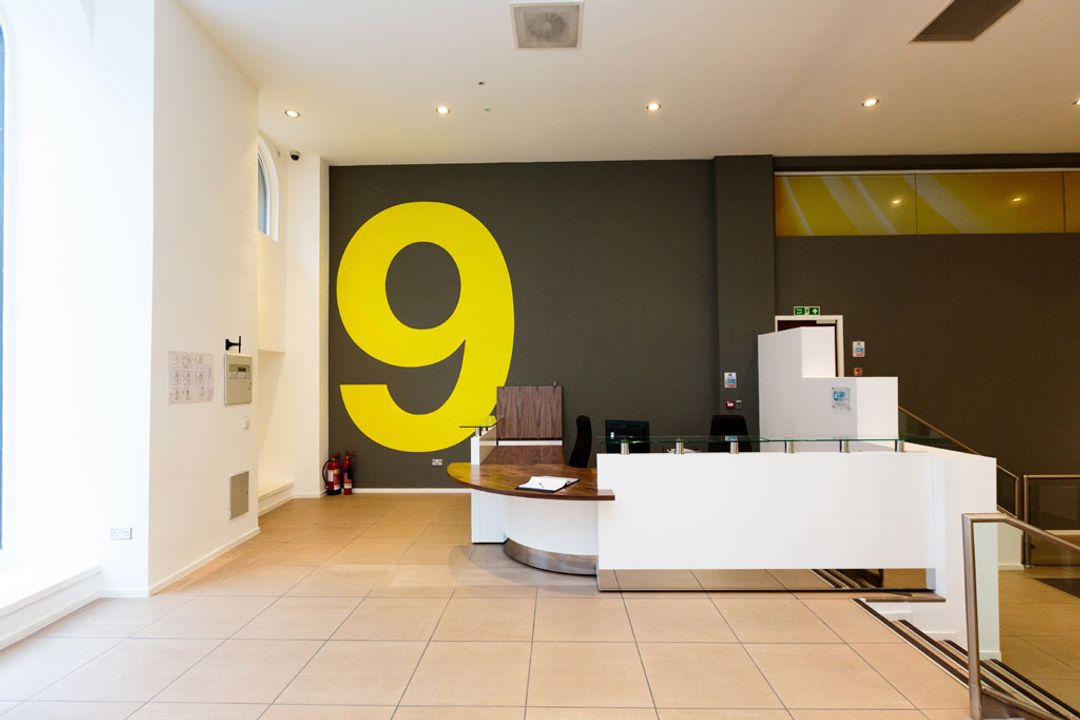 Reception counter with walnut veneer work surface and glass shelves
