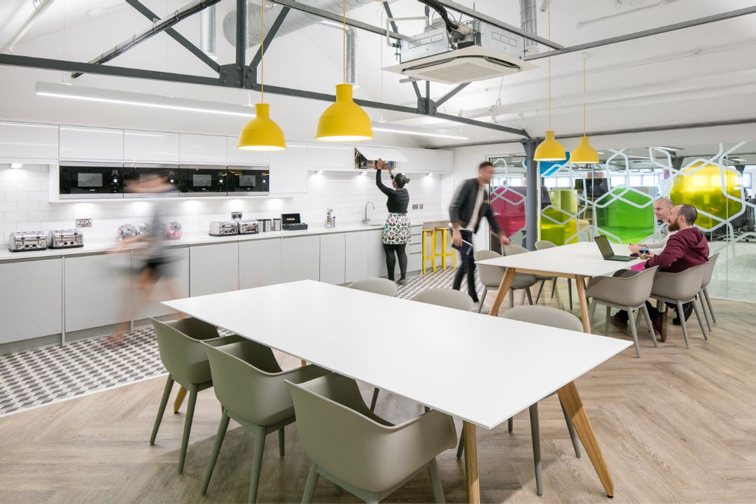 Car Finance 247 - 6th Floor Kitchen Dining Space showing Sven Ligni Tables with Oak Legs and white tops complete with Muuto's Fiber and Visu Chairs and lit by Muuto's Unfold Pendant Lamps in Yellow.